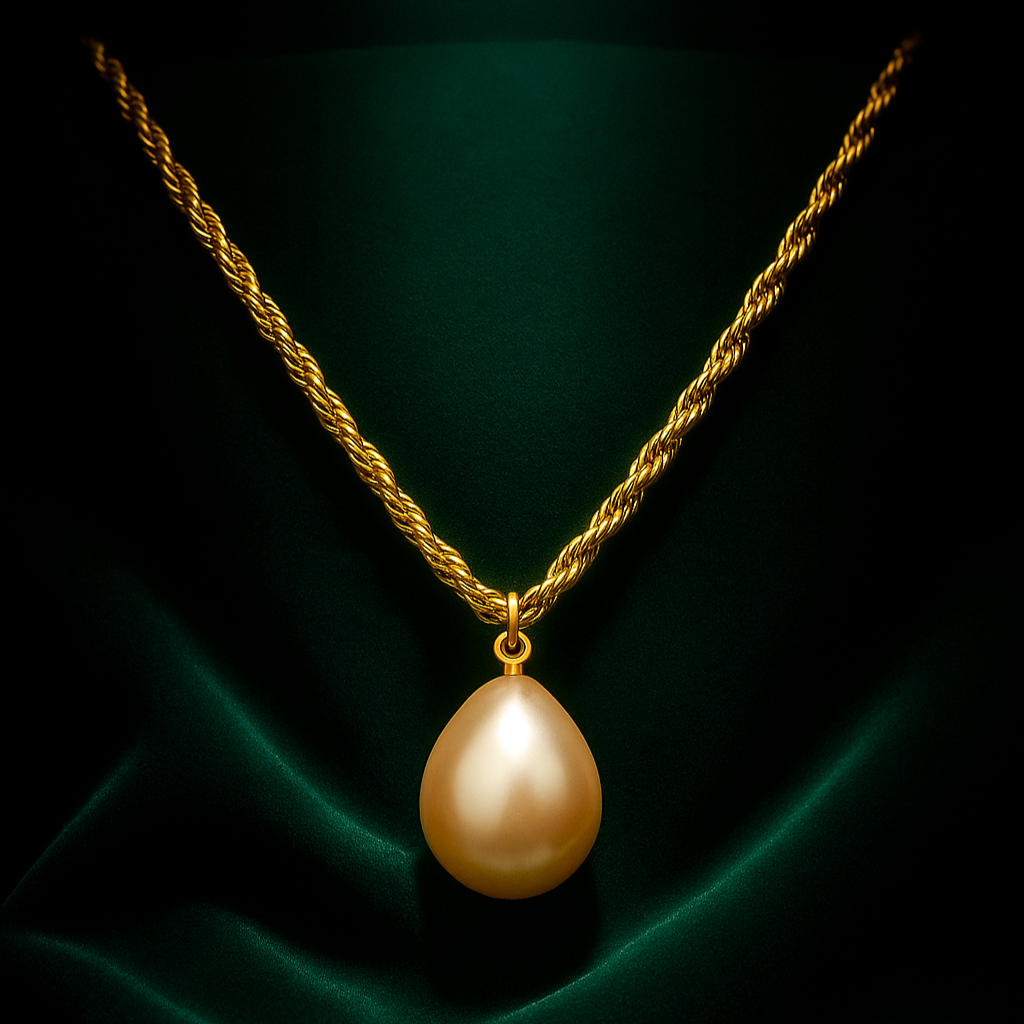 Gold necklace with a large pearl pendant on a dark green fabric background