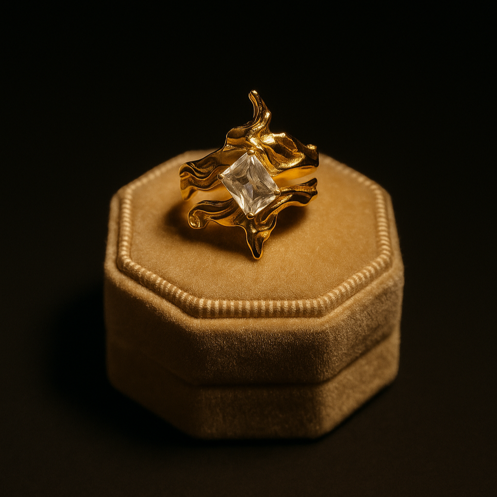 Gold ring with a large diamond on a beige cushion against a black background