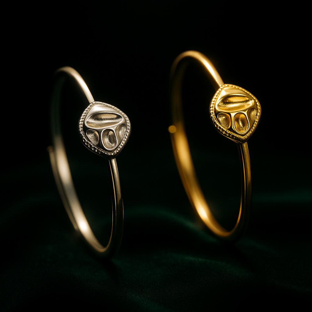 Gold and silver bangles with a decorative design on a dark background