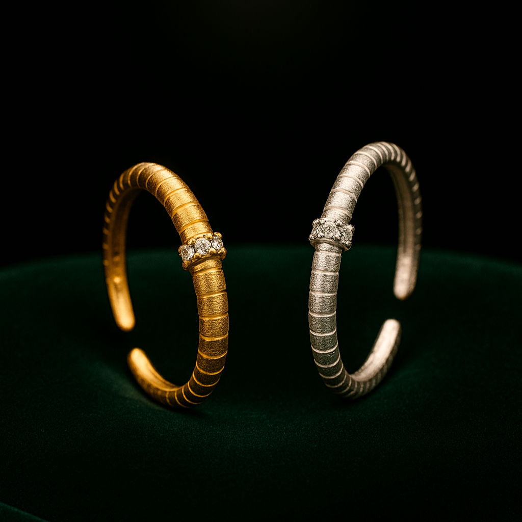 Two bracelets, one gold and one silver, on a dark green surface with a black background.