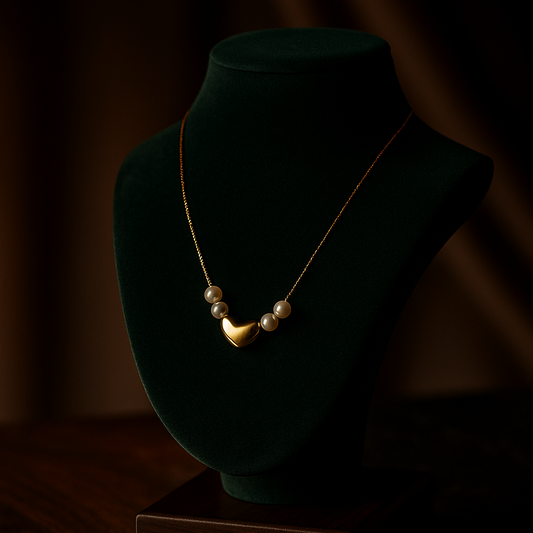 Necklace on a green velvet bust against a dark background