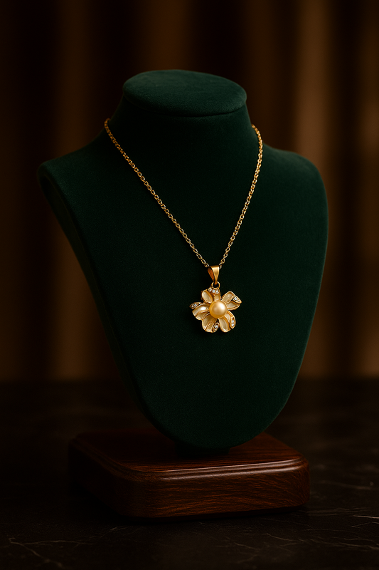 Gold necklace with a floral pendant on a green mannequin bust against a dark background