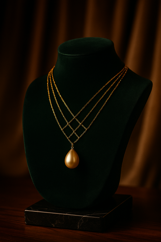 Gold necklace with a pendant on a black mannequin bust against a dark background
