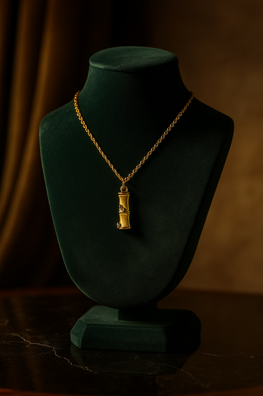 Gold necklace with a pendant on a green mannequin bust against a dark background