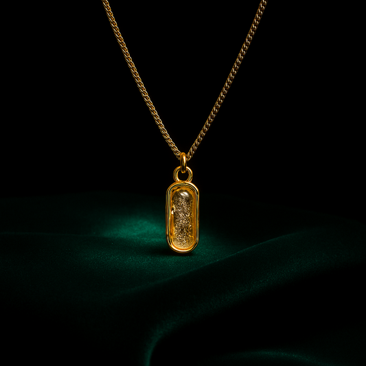Gold necklace with a pendant on a dark background