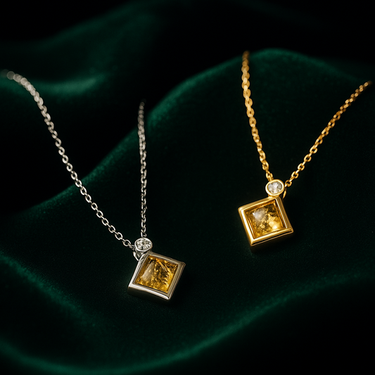 Two necklaces with square pendants on a dark background