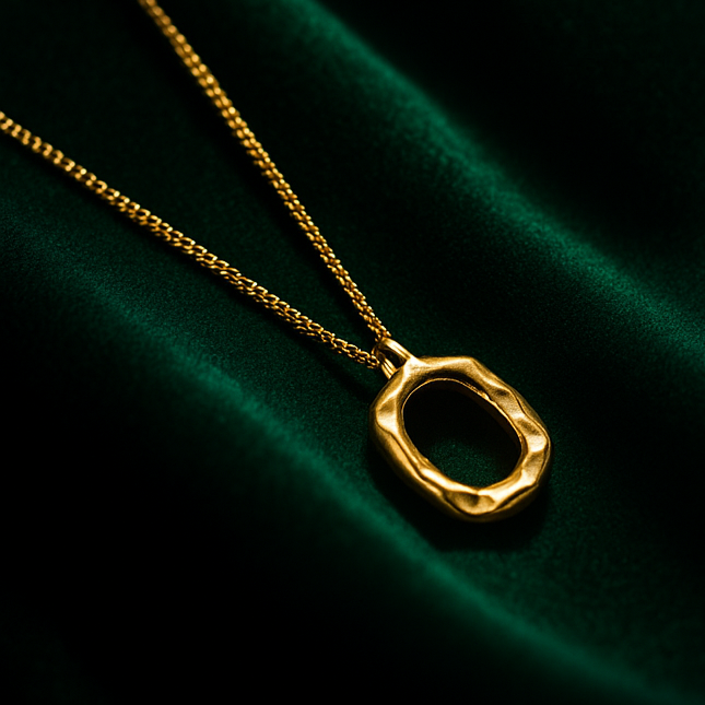 Two necklaces with unique circular pendants on a dark green fabric background