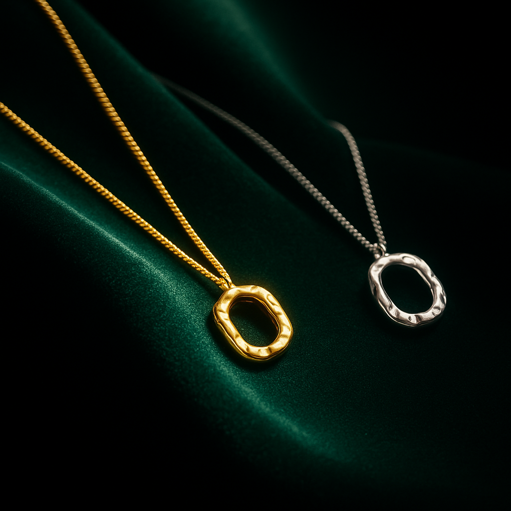 Two necklaces with circular pendants on a dark green fabric background