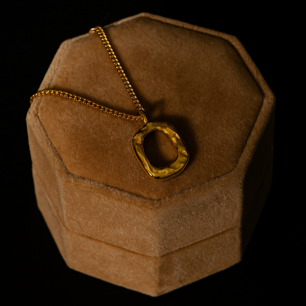 Gold necklace on a brown velvet jewelry box against a black background