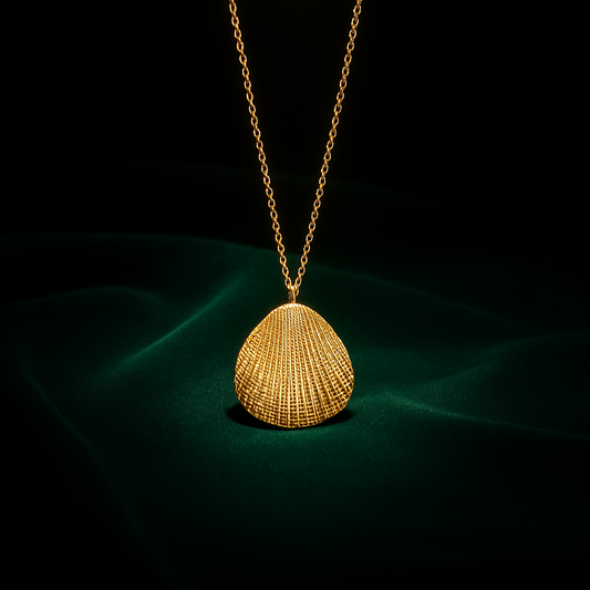 Gold necklace with a shell pendant on a dark background