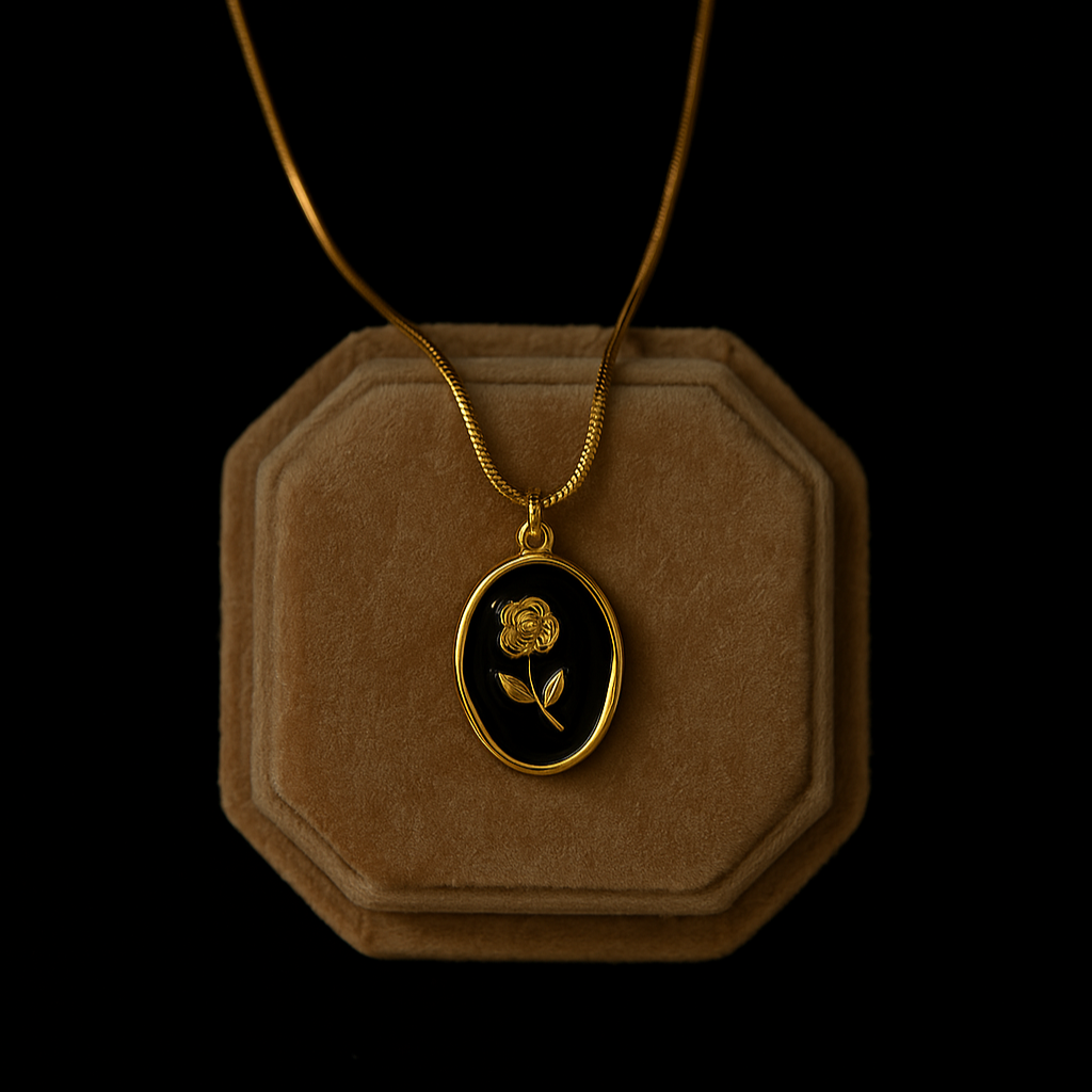 Gold necklace with a rose pendant on a brown velvet stand against a black background
