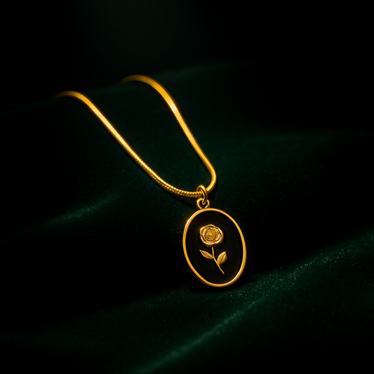 Gold necklace with a pendant featuring a rose design on a dark background