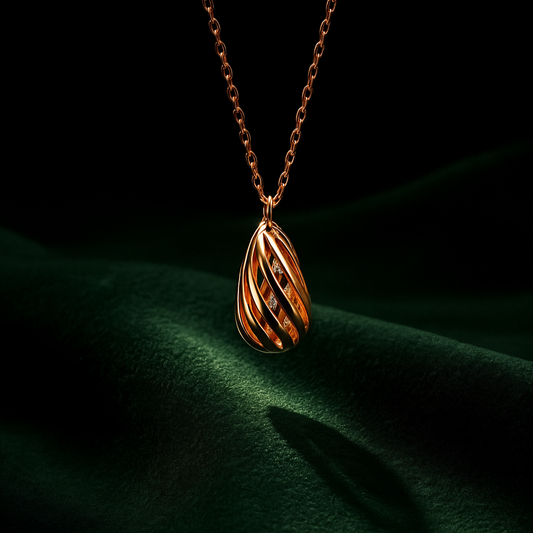 Rose gold necklace with a teardrop-shaped pendant on a dark green fabric background