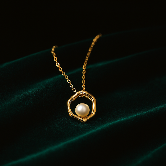 Gold necklace with a pearl pendant on a dark background