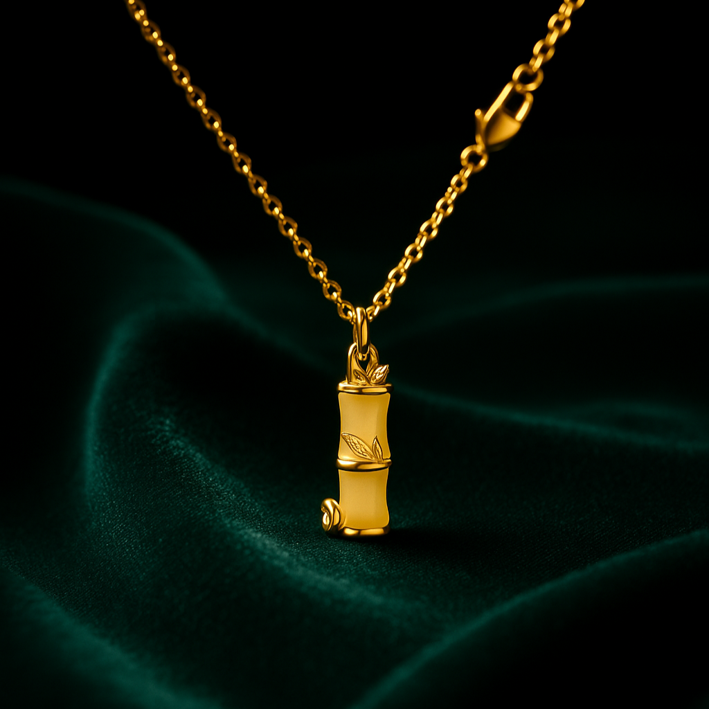 Gold necklace with a small gold box pendant on a dark green fabric background