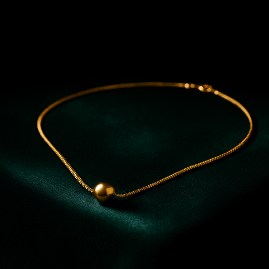 Gold necklace on a dark green surface