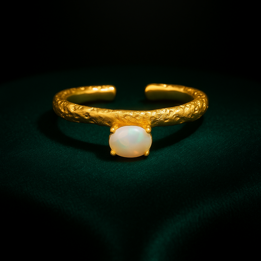 Gold ring with a central gemstone on a dark background